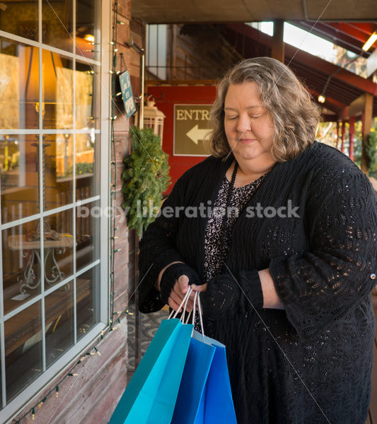 Shopping & Retail Stock Photo: Plus Size Woman with Shopping Bags Outside Small Boutique Store - Body Liberation Photos