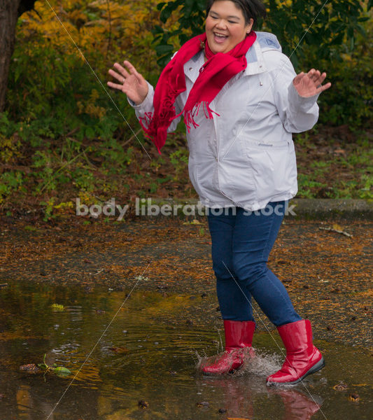 Stock Photo: Asian American Woman Playing in Puddles on a Rainy Day - Body Liberation Photos