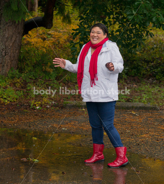 Stock Photo: Asian American Woman Playing in Puddles on a Rainy Day - Body Liberation Photos