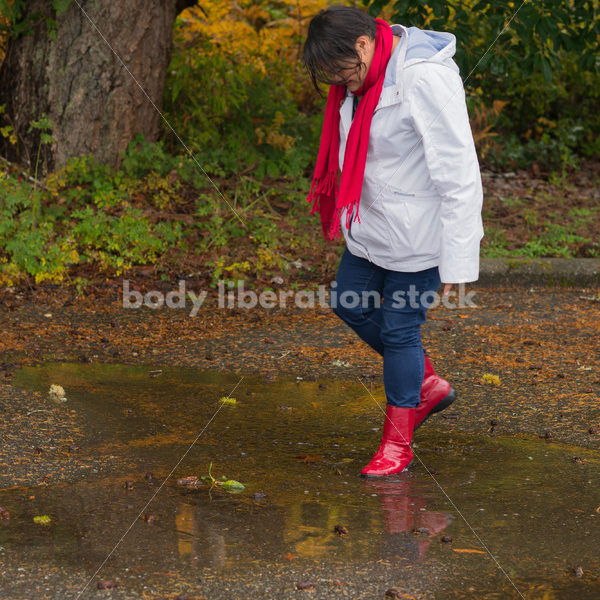 Stock Photo: Asian American Woman Playing in Puddles on a Rainy Day - Body Liberation Photos