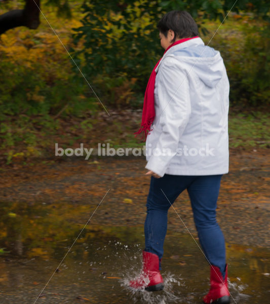 Stock Photo: Asian American Woman Playing in Puddles on a Rainy Day - Body Liberation Photos