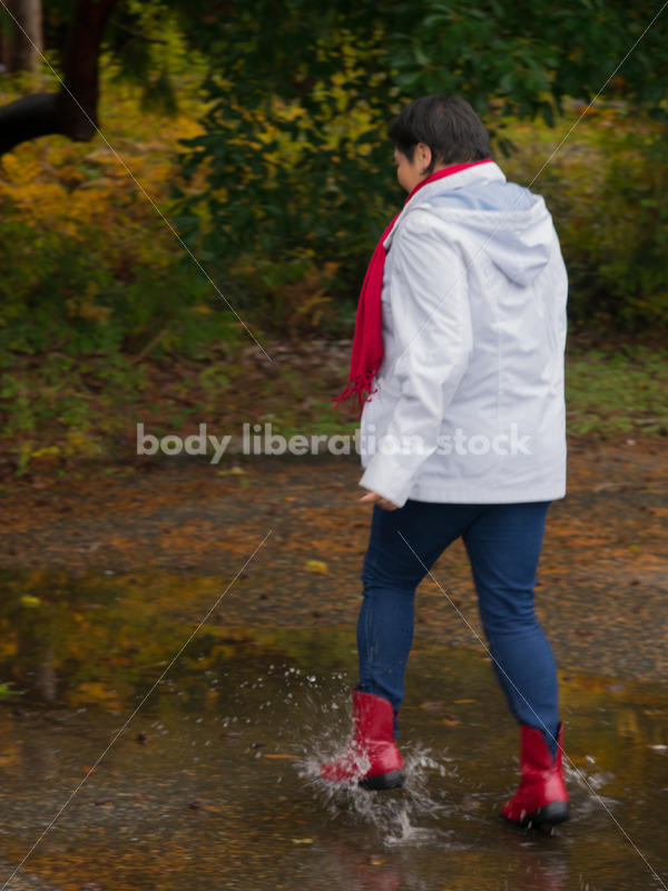 Stock Photo: Asian American Woman Playing in Puddles on a Rainy Day - Body Liberation Photos