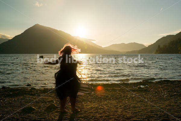 Stock Photo: Plus Size Woman Twirling Sihouette on Mountain Lake Shore at Sunset - Body Liberation Photos