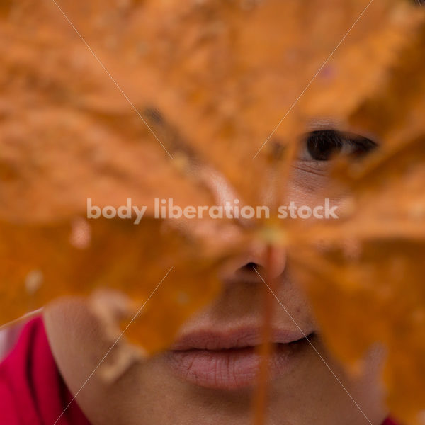 Stock Photo: Young Asian American Woman Holding Autumn Leaf Mask - Body Liberation Photos