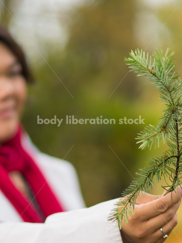 Stock Photo: Young Asian American Woman Holding Pine Branch - Body Liberation Photos