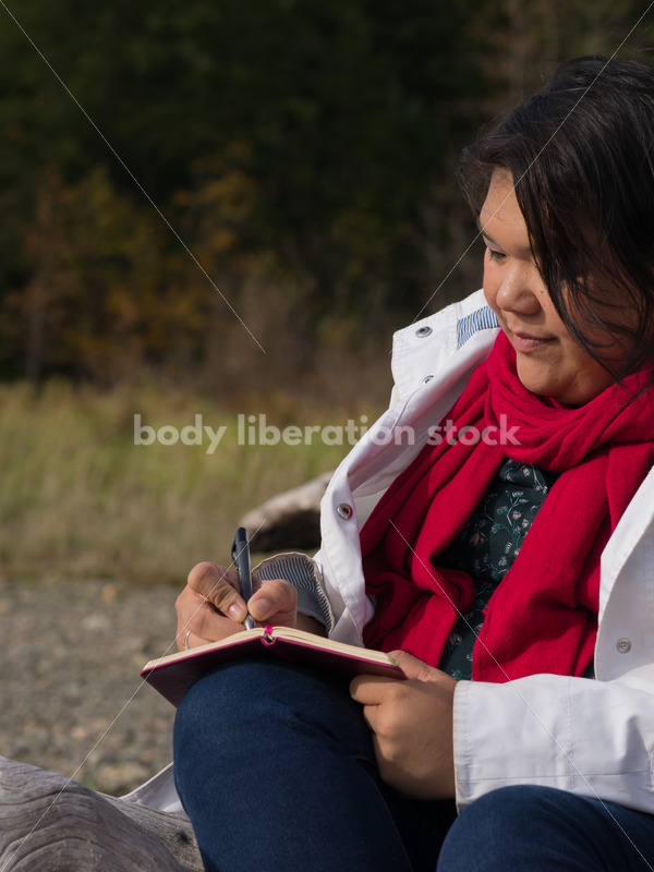 Stock Photo: Young Asian American Woman Writing in Journal Outdoors - Body Liberation Photos
