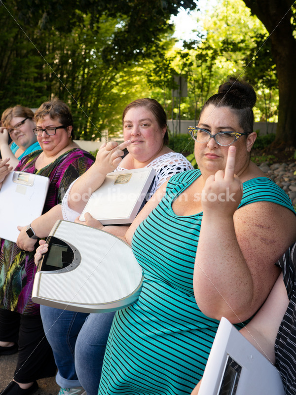 Anti-Diet Stock Image: Women Give the Finger to Bathroom Scales - Body Liberation Photos