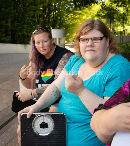 Anti-Diet Stock Image: Women Give the Finger to Bathroom Scales - Body Liberation Photos