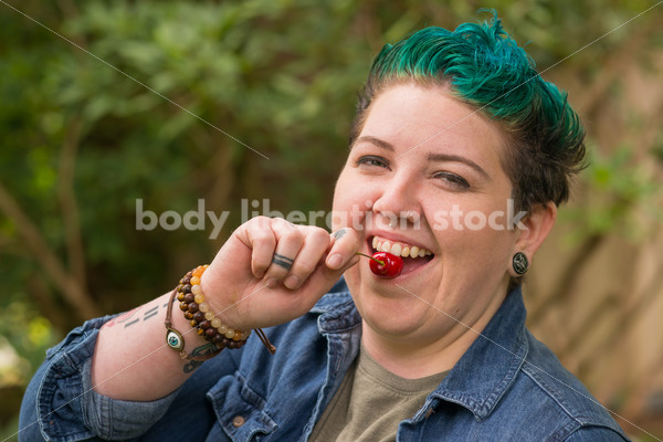 Diverse Gardening Stock Photo: Agender Person Eats Cherries in Garden - Body Liberation Photos