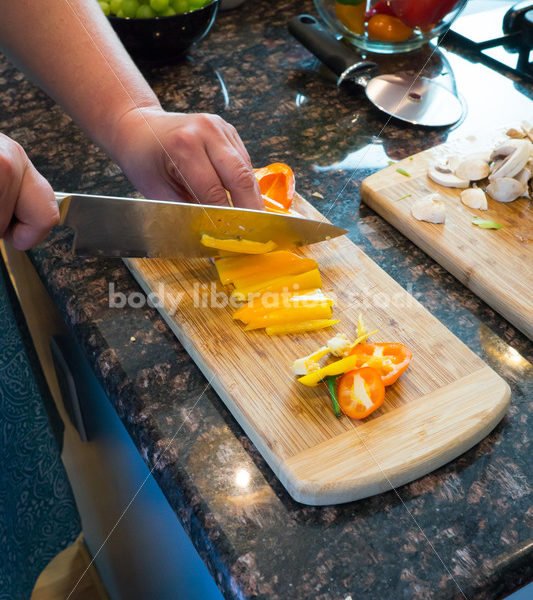 Eating Disorder Recovery Stock Photo: Woman Chopping Peppers on Kitchen Counter - Body Liberation Photos