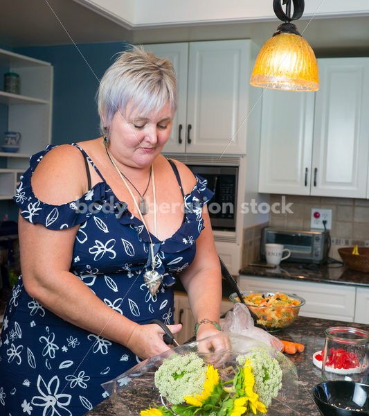 Eating Disorder Recovery Stock Photo: Woman Cuts Flowers in Kitchen - Body Liberation Photos