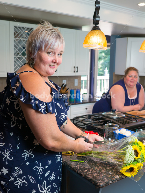 Eating Disorder Recovery Stock Photo: Woman Cuts Flowers in Kitchen - Body Liberation Photos