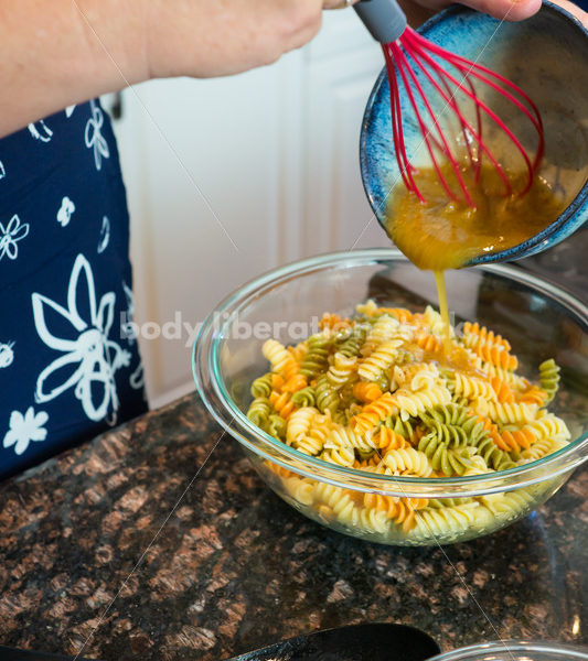 Eating Disorder Recovery Stock Photo: Woman Makes Pasta Salad in Kitchen - Body Liberation Photos