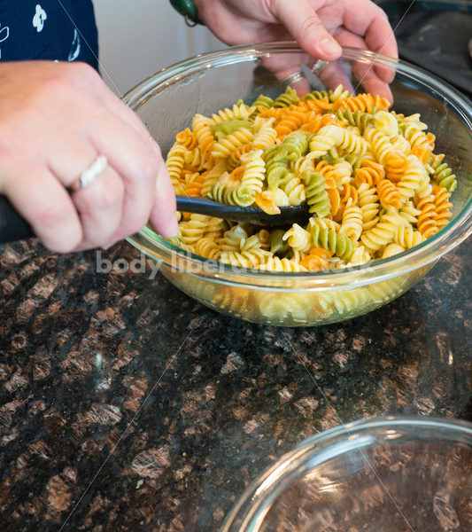 Eating Disorder Recovery Stock Photo: Woman Makes Pasta Salad in Kitchen - Body Liberation Photos