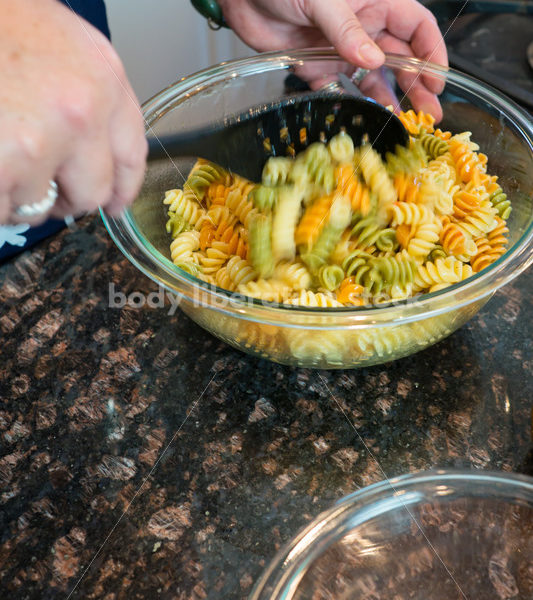 Eating Disorder Recovery Stock Photo: Woman Makes Pasta Salad in Kitchen - Body Liberation Photos