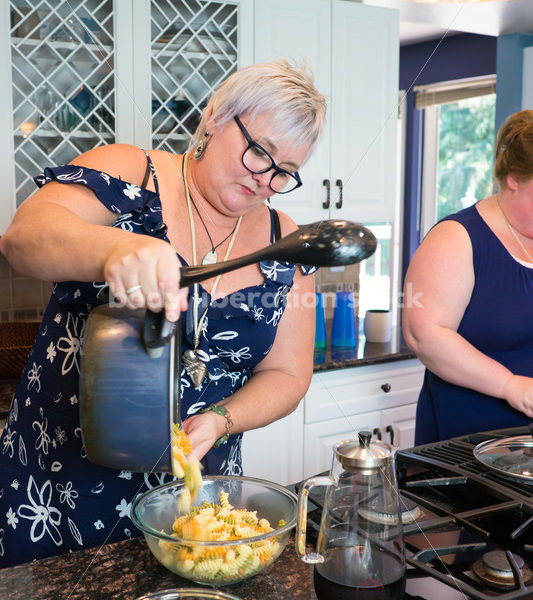 Eating Disorder Recovery Stock Photo: Woman Pours Pasta in Kitchen - Body Liberation Photos