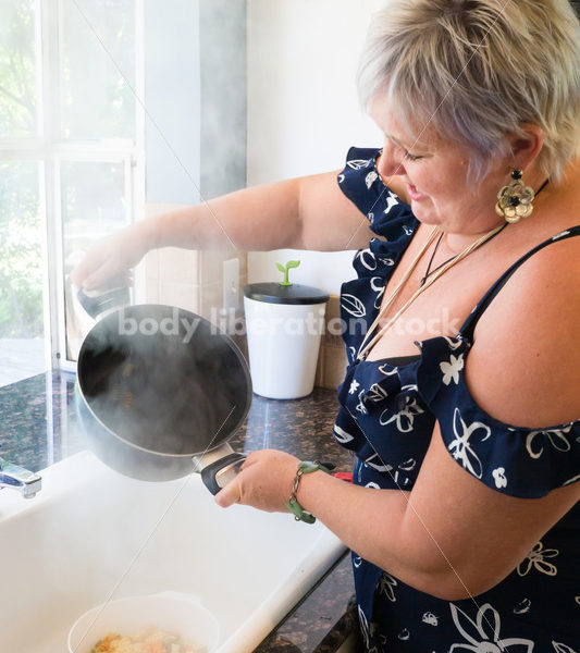 Eating Disorder Recovery Stock Photo: Woman Strains Pasta in Pot of Water in Kitchen - Body Liberation Photos