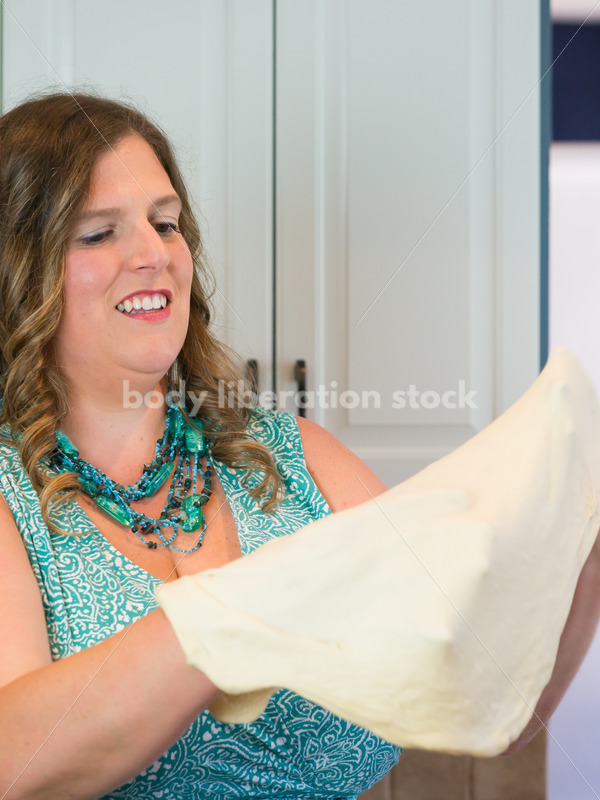 Eating Disorder Recovery Stock Photo: Woman Tossing Pizza Dough in Kitchen - Body Liberation Photos