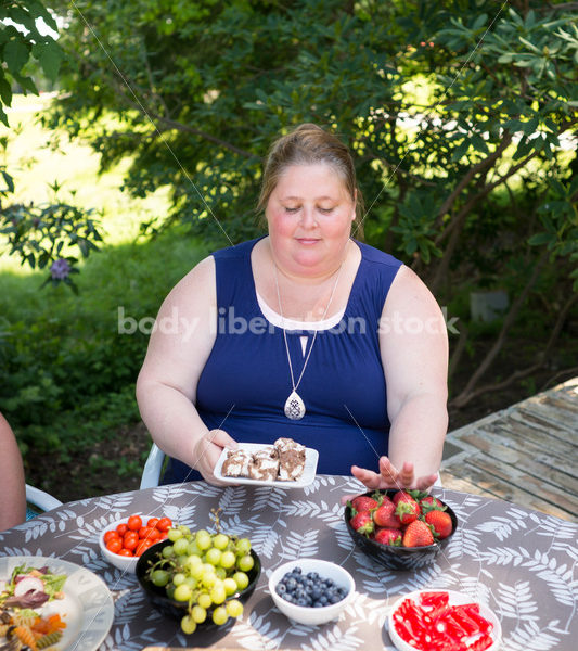 Intuitive Eating Stock Image: Woman Chooses Foods During Outdoor Meal - Body Liberation Photos