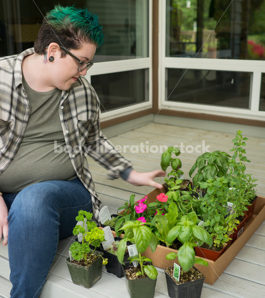 Stock Photo: Agender Person Chooses Plants while Gardening - Body Liberation Photos