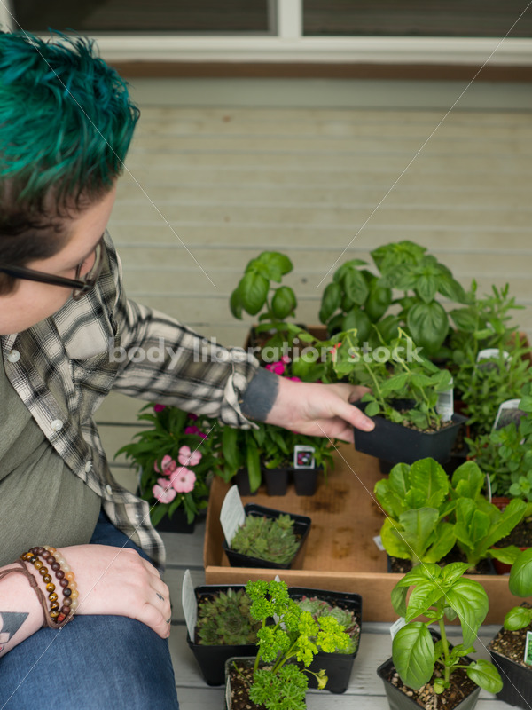 Stock Photo: Agender Person Chooses Plants while Gardening - Body Liberation Photos