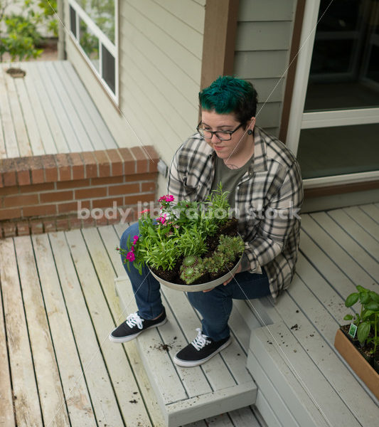 Stock Photo: Agender Person Chooses Plants while Gardening - Body Liberation Photos