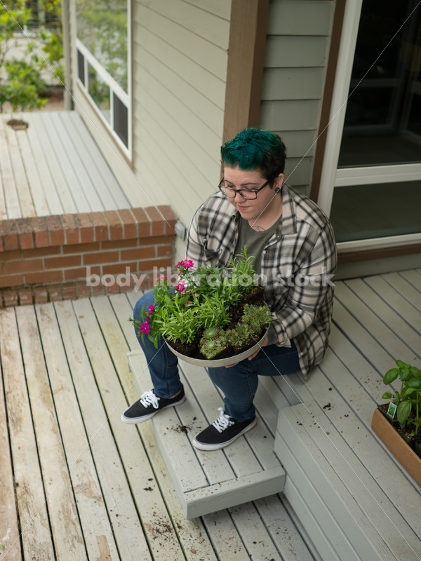 Stock Photo: Agender Person Chooses Plants while Gardening - Body Liberation Photos
