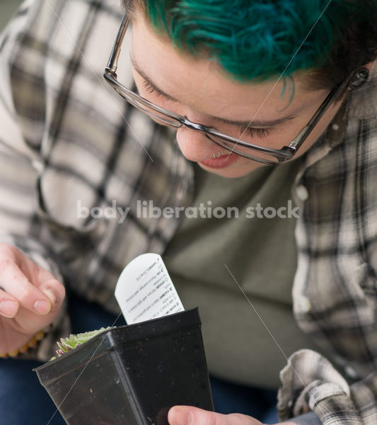 Stock Photo: Agender Person Holding Plant while Gardening - Body Liberation Photos