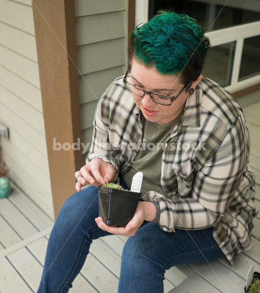 Stock Photo: Agender Person Holding Plant while Gardening - Body Liberation Photos