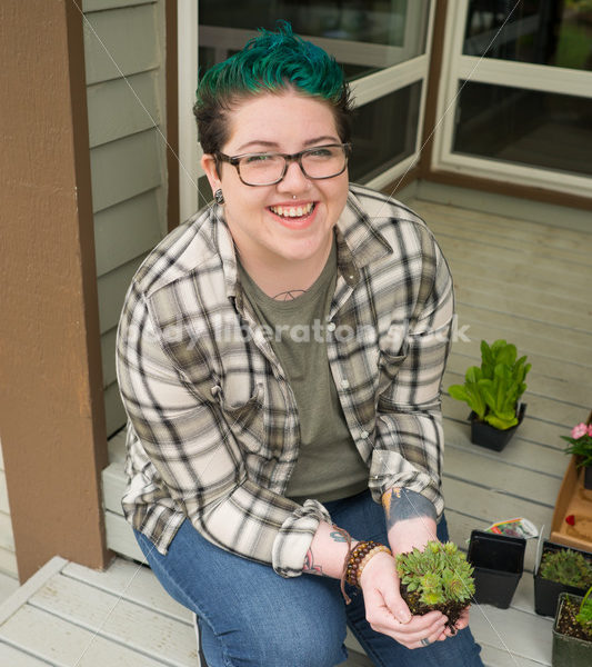 Stock Photo: Agender Person Holding Plant while Gardening - Body Liberation Photos