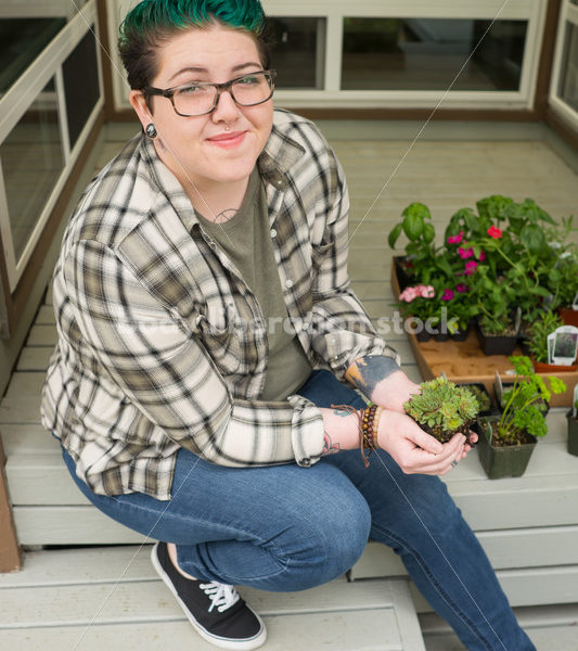 Stock Photo: Agender Person Holding Plant while Gardening - Body Liberation Photos