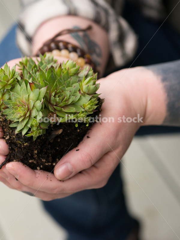Stock Photo: Agender Person Holding Plant while Gardening - Body Liberation Photos