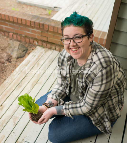 Stock Photo: Agender Person Holding Plant while Gardening - Body Liberation Photos