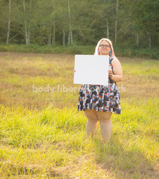 Blank Sign Stock Image: Woman in Field with Sign, Ready for Copy - Body Liberation Photos