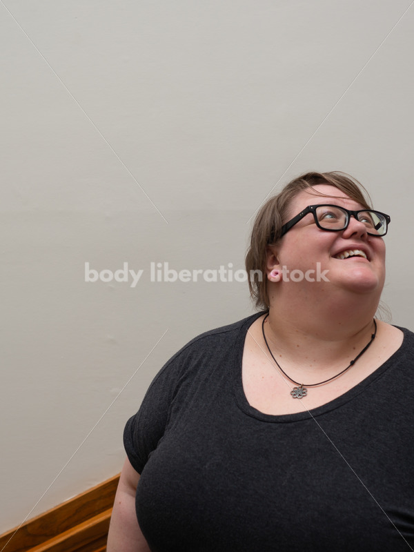 Fat woman in stairwell, looking up - Body Liberation Photos