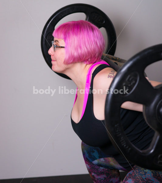 HAES Stock Photo: Female Weightlifter with Pink Hair Does Squat in Gym - Body Liberation Photos