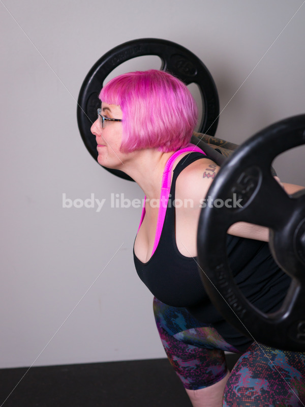 HAES Stock Photo: Female Weightlifter with Pink Hair Does Squat in Gym - Body Liberation Photos