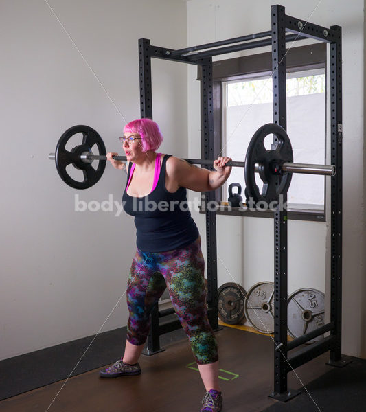 HAES Stock Photo: Female Weightlifter with Pink Hair Does Squat in Gym - Body Liberation Photos