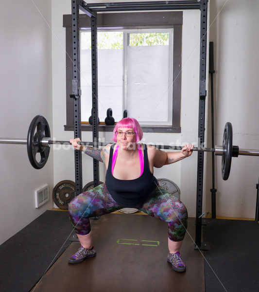 HAES Stock Photo: Female Weightlifter with Pink Hair Does Squat in Gym - Body Liberation Photos