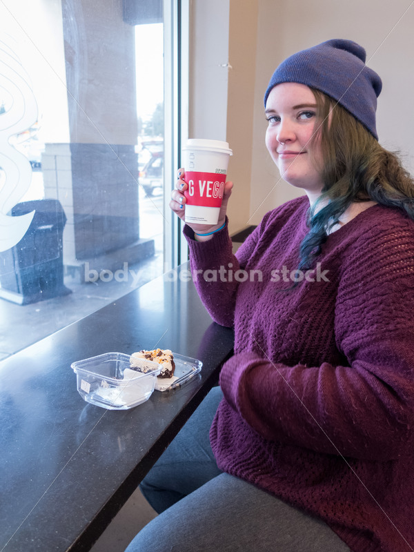 Young caucasian women enjoys coffee and a brownie