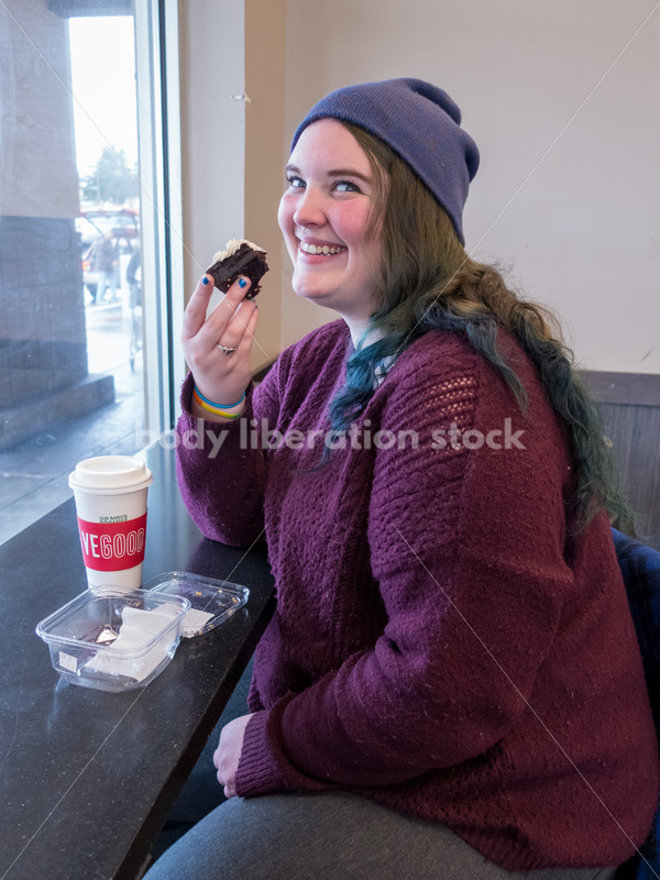 Young caucasian women enjoys coffee and a brownie
