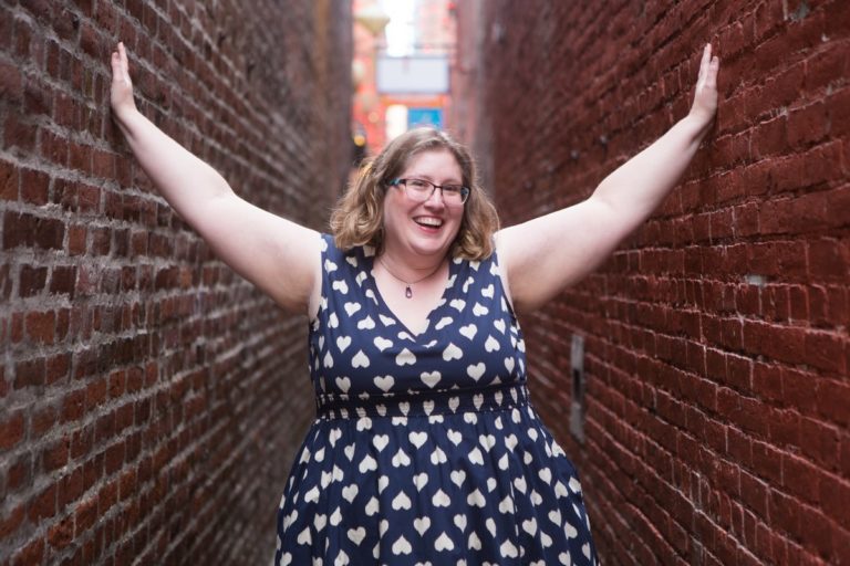 Lindley, a fat white woman, stands in a narrow brick alley with her hands on the walls.