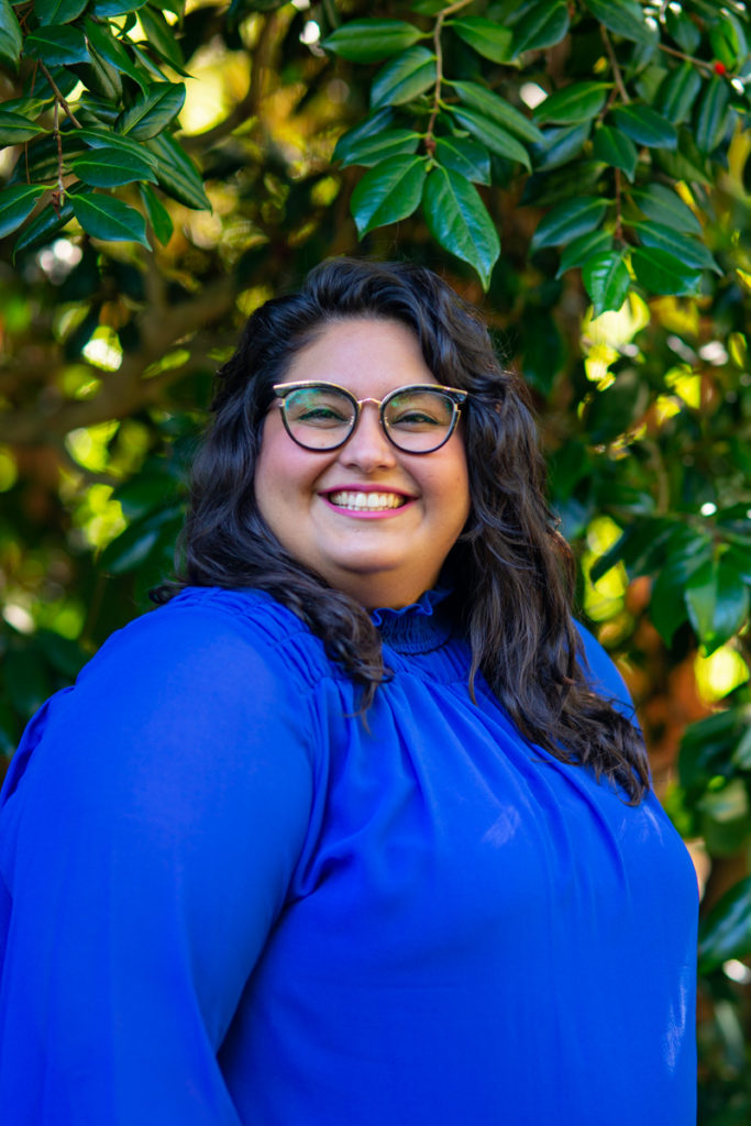  A fat woman smiles cheerfully at the camera for a business headshot in the PNW