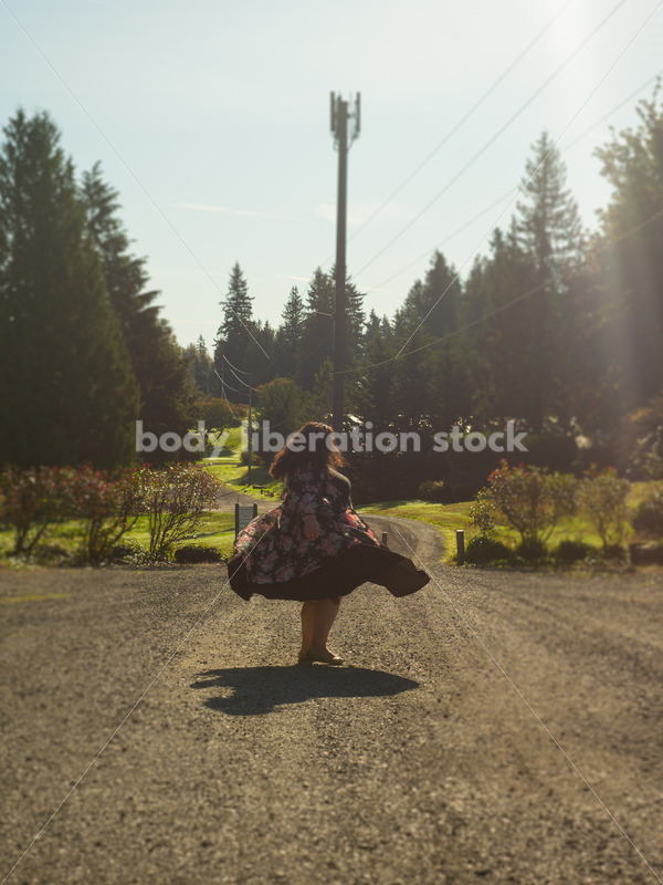 Inclusive Stock Photo: Plus-Size Woman Twirls on Gravel Road - Body liberation boudoir, portraits, stock, HAES & more | Seattle