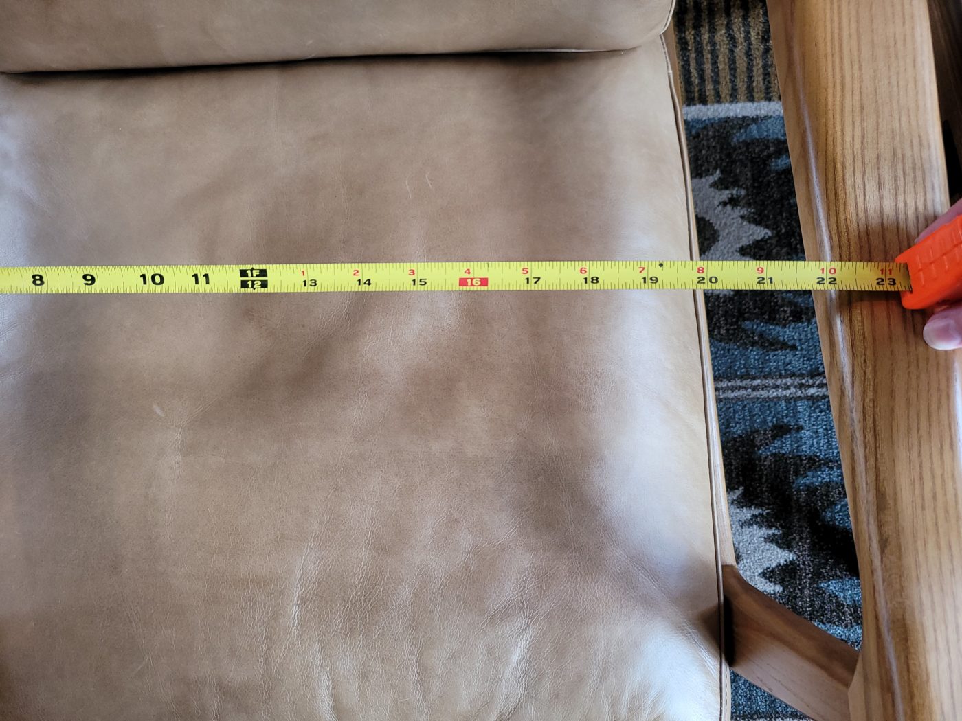 A tan upholstered chair with wooden arms, with a tape measure stretched across it at Alderbrook Resort where the Exhale fat-positive retreat will be held.