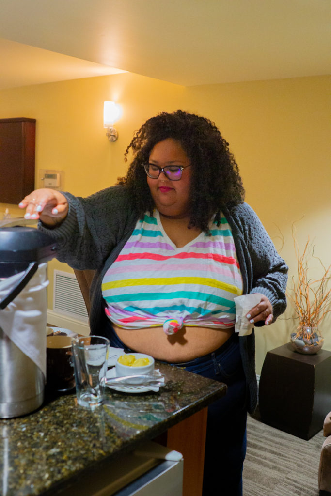  A fat Brown woman wearing a crop top works over a mixer in a kitchen in the PNW