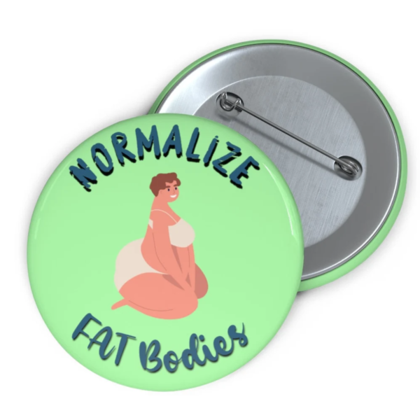 A green button or pin that says Normalize Fat Bodies and features an illustration of a fat feminine person with short hair and underwear.