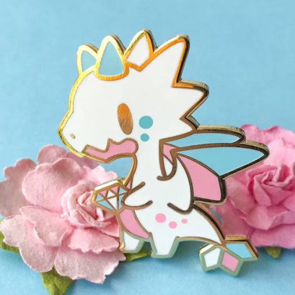 Trans Pride Dragon Enamel Pin with a cute white, pink and blue kawaii dragon holding a gemstone