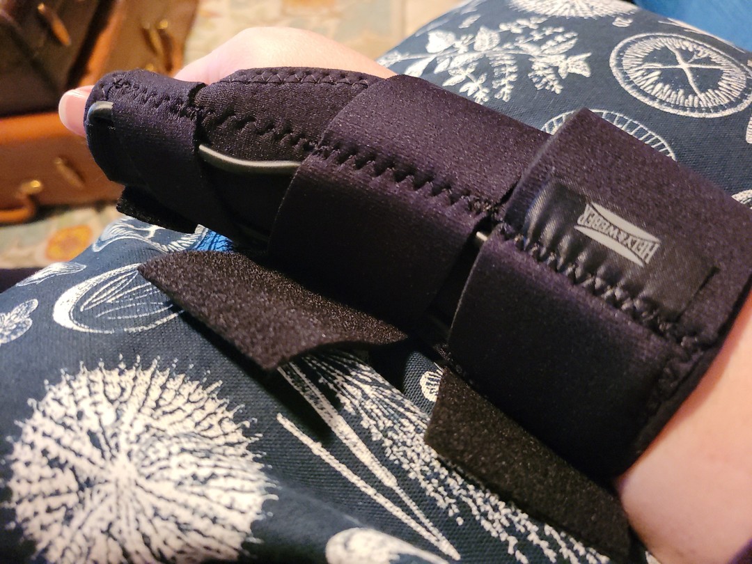 Lindley's hand in a medical brace resting on a pillow