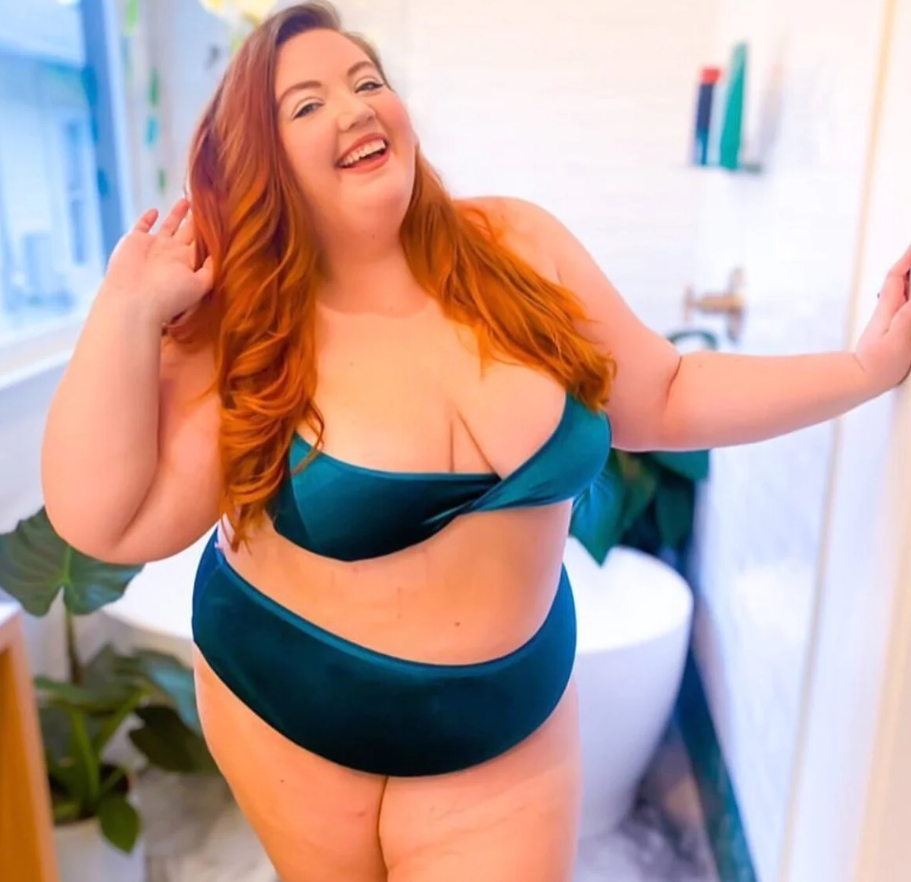 Image description: A fat white person with red hair poses in a matching set of blue bra and panties